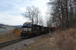 NS 228 climbs Linden Hill at the scenic Fiery Run Road crossing led by ES-44DC #7700 on 3/8/2017.