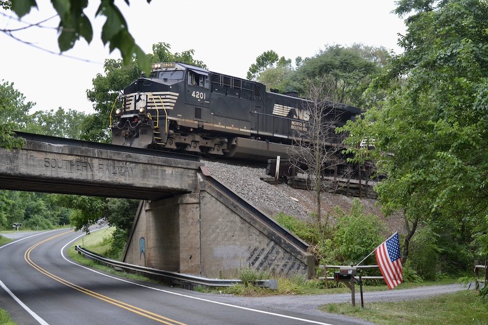 Norfolk Southern train passes an American flag on the Fourth of July.