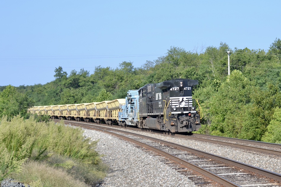 A train to dump new ballast along the railroad tracks.