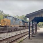 A CSX freight train passes a covered station platform in Duffields, West Virginia