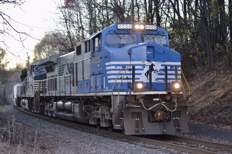 A specially painted Norfolk Southern locomotive with a blue front leads an intermodal train.