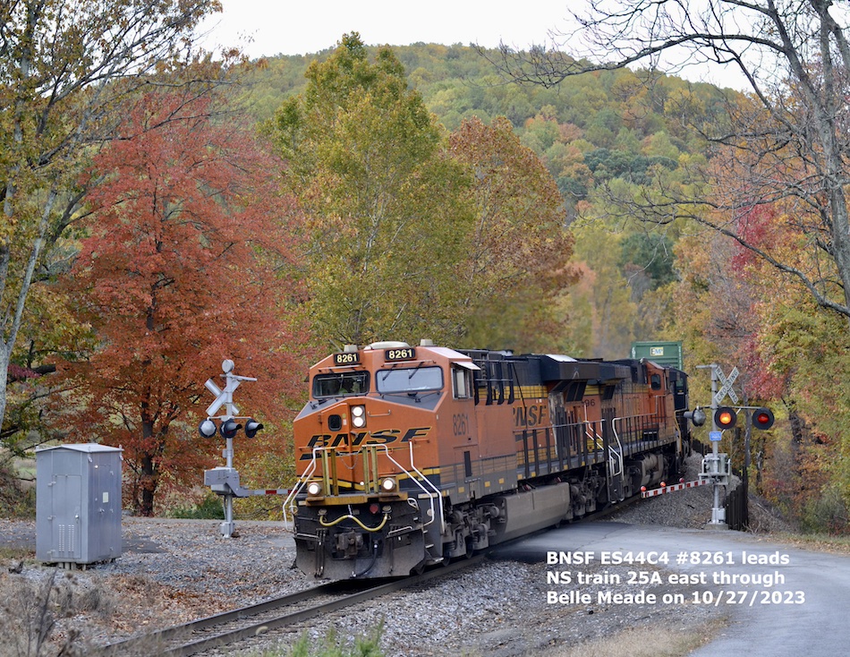 Colorful Burlington Northern Santa Fe locomotives passing through fall foliage 