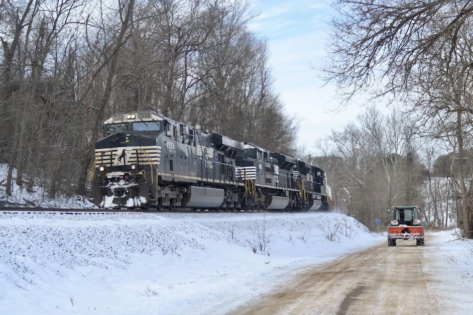 A train passes alongside a snow roadway in rural Virginia