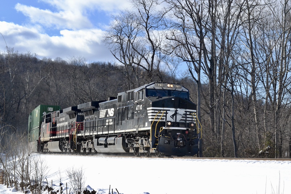 A Norfolk Southern intermodal train passes through a pretty winter scene